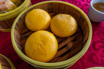 Steamer basket containing custard buns, served as part of dim sum, popular in south-eastern Asia, at a restaurant in George Town, Penang, Malaysia.