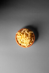 pasta in a mud bowl  on a dark grey baakground