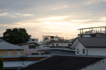 Warm sky and clouds after sunset in the evening in village. Cityscape Sunset in Bangkok, Thailand