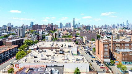 Fototapeta premium A stunning aerial view of Brooklyn, NY, showcasing vibrant city streets and diverse architecture with the iconic New York City skyline in the background. 