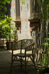 An empty wicker chair in the shadows.