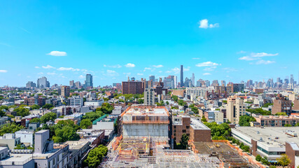 Obraz premium A stunning aerial view of Brooklyn, NY, showcasing vibrant city streets and diverse architecture with the iconic New York City skyline in the background. 