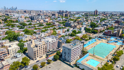 Obraz premium A stunning aerial view of Brooklyn, NY, showcasing vibrant city streets and diverse architecture with the iconic New York City skyline in the background. 