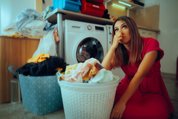 Woman Sitting Next to Some Stinky Laundry Ready to Wash it. Housewife disgusted with the musty...