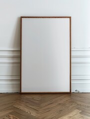 Minimalist Interior Decor: Large Wooden Frame Resting Against White Wall on Wood Floor, Close-Up View.