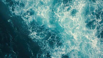 From above aerial view of turquoise ocean water with splashes and foam for abstract natural background and texture. 