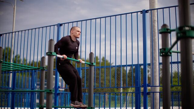 Impressive muscle-up exercise by athlete on outdoor bar