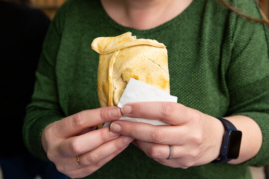 Woman holding a Chilean meat empanada during Chile's national holidays, which are celebrated on September 18th throughout the country