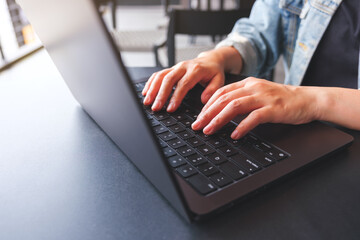 Closeup image of a woman hands working and typing on laptop computer keyboard