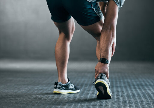 Man, hands and ankle injury for fitness, exercise and workout accident in gym with inflammation or sprain. Male person, legs and muscle pain for sports emergency, tendon and anatomy with rear view