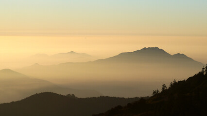 Mountains in foggy haze in morning light, mystical landscape