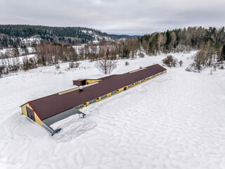 Aerial photo of forest, lake and agricultural land in the winter. Aerial view of non-working Livestock farm in Karelia