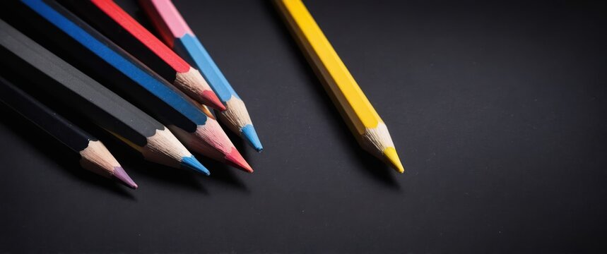 Colorful pencils arranged on a black background, perfect for art and creativity