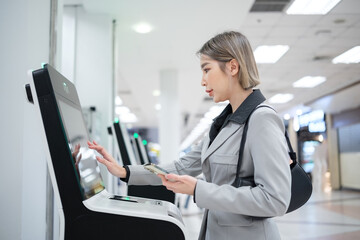 A woman is standing in front of a machine and putting money in it