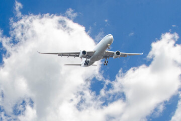 White passenger airplane flying in the sky amazing clouds in the background