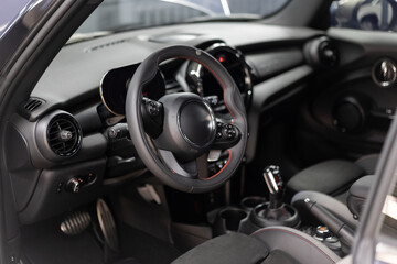 Modern car interior with a steering wheel and control elements on the dashboard
