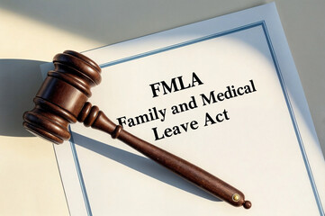 A wooden gavel on the peace of paper with the word phrase text "FMLA abbreviation acronym for Family and Medical Leave Act
