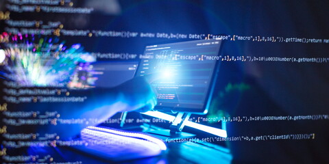 Programmer manually working with program code on a computer at night in a data center