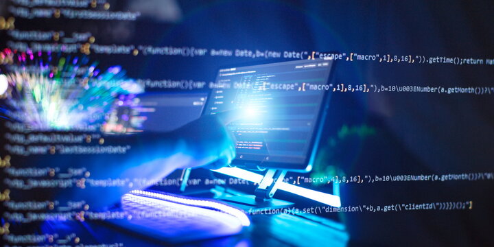 Programmer manually working with program code on a computer at night in a data center