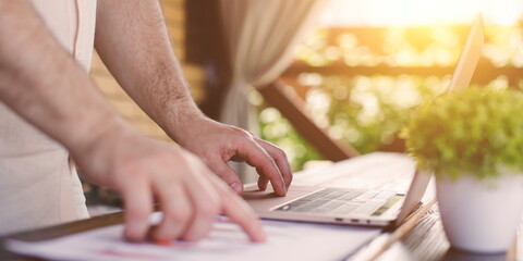 online work from home. A man plans a daily meeting and records a business trip on a laptop at his desk. Event planning concept with calendar reminder.