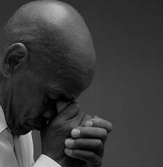 man praying to god with hands together Caribbean man praying with black grey background with people stock image stock photo	