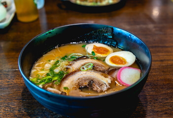 Japanese noodle soup ramen with egg and pork in black ramen bowl for Japanese food style.