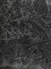 Chrystal clear frosty textured natural ice block in cold shades of grey tones, isolated on black background.