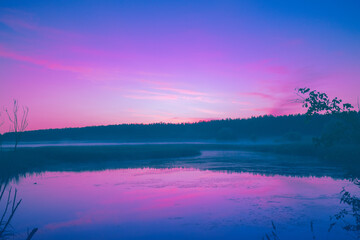 Fototapeta premium Magical sunrise over the lake. Misty early morning. Serenity lake in magical light