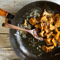 cast iron frying pan with fried chanterelles on the table © kochabamba