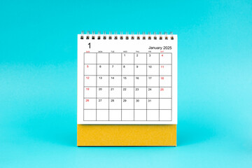 January 2025 desk calendar on blue background.