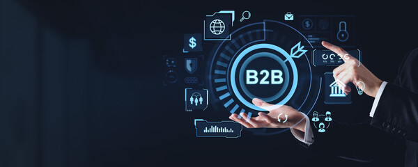 Businessman interacting with B2B digital interface on dark background.