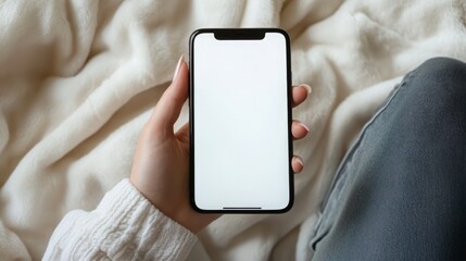 Stylish Woman Holding a Mock-up Smartphone Displaying a White Screen for Creative Content Presentation