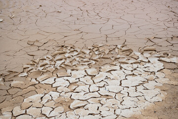 High-resolution image showcasing a detailed view of a dried and deeply cracked desert sand surface, highlighting natural earth patterns