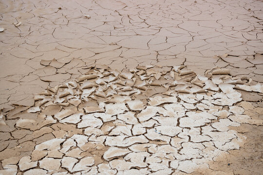 High-resolution image showcasing a detailed view of a dried and deeply cracked desert sand surface, highlighting natural earth patterns