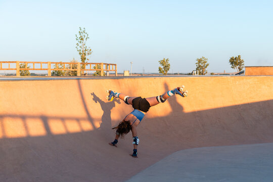 Young girl performing tricks on roller skates in park