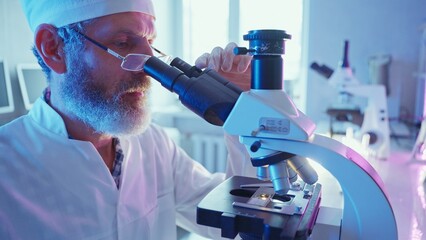 Chemist Analyzing Samples Under Microscope in Innovative Laboratory Setting
