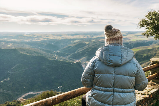 Anonymous person admiring Cachon del Camaces waterfall from viewpoint