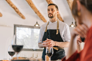 Private chef engaging with guests at a home dinner party