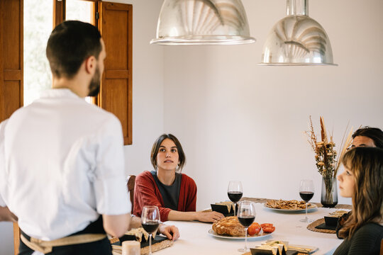 Private chef serves meal to friends at a stylish home dinner