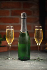 Green bottle of champagne and two glasses