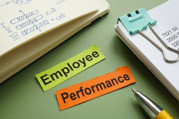 Employee performance written on pieces of paper on an office desk.