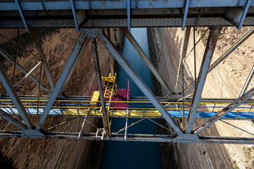 Top view of the Corinth Canal, showcasing the metal bridge structure and the narrow waterway...