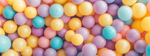 Fototapeta premium Lots of shiny bright purple, yellow, blue plastic balls balloons, kids birthday party playground attraction background close up concept.background with copy for greeting card, banner, poster 