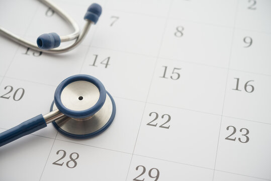 Stethoscope on white blank calendar background. Doctor appointment date reminder in hospital clinic center for health checkup, see condition and treatment. Healthcare, healthy lifestyle concept.