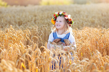 Child in wheat field with German bread