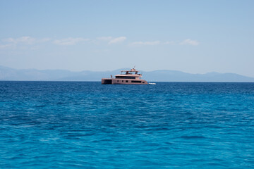 Obraz premium Pink luxury catamaran sailing in a summer day on crystal sea or ocean, expensive holiday concept
