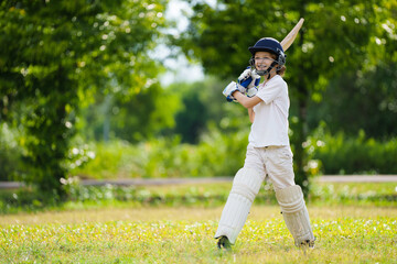 Kids playing cricket in summer park