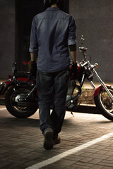Naklejka premium a man on a red chopper motorcycle. guy on a bike at night.