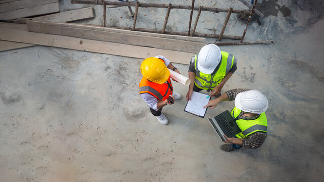 Top view of architects engineer are discussing about the progress of the building project and checking the accuracy of the building structure.