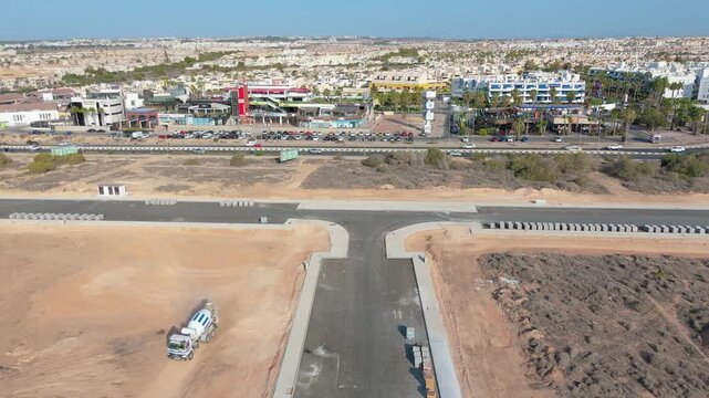 Drone shot captures the ongoing development and construction in Playa Flamenca, showcasing urban expansion along the bustling coastline of Orihuela, Costa Blanca, Spain.
